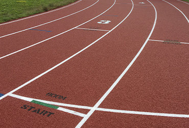 Close up view of a sprinting track with white race lines.