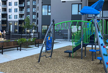 Green and Blue jungle gym near an apartment